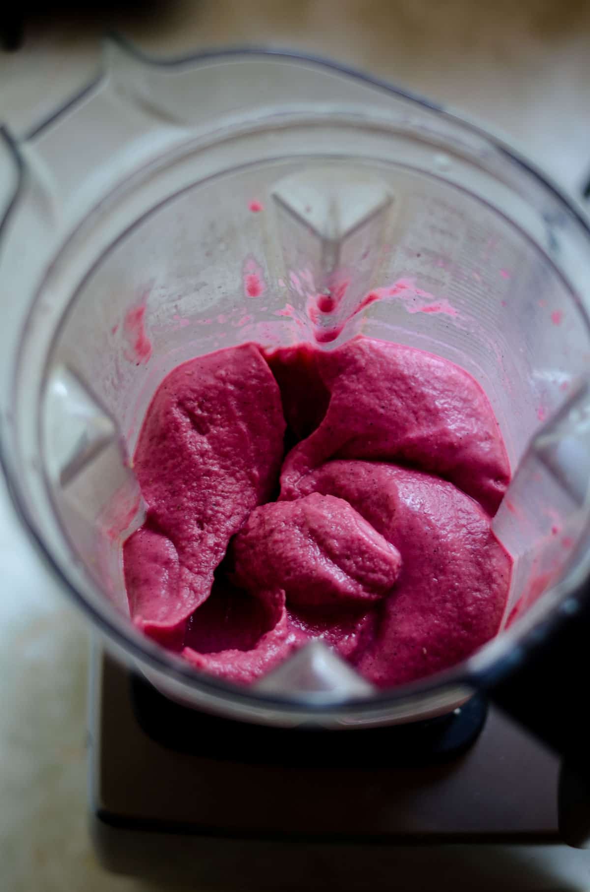 Thick creamy pink smoothie in the blender container.