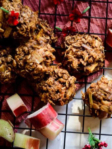 Cookies with oats on cooling rack with rhubarb beside them.