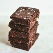 Dark brown stacked homemade rx bars with sea salt on top.