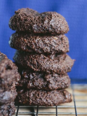 Brownie cookies stacked on a cooling rack.