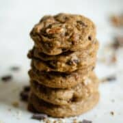 5 olive oil cookies stacked, showing chocolate and almonds.