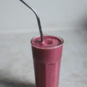 Strawberry smoothie with metal straw.