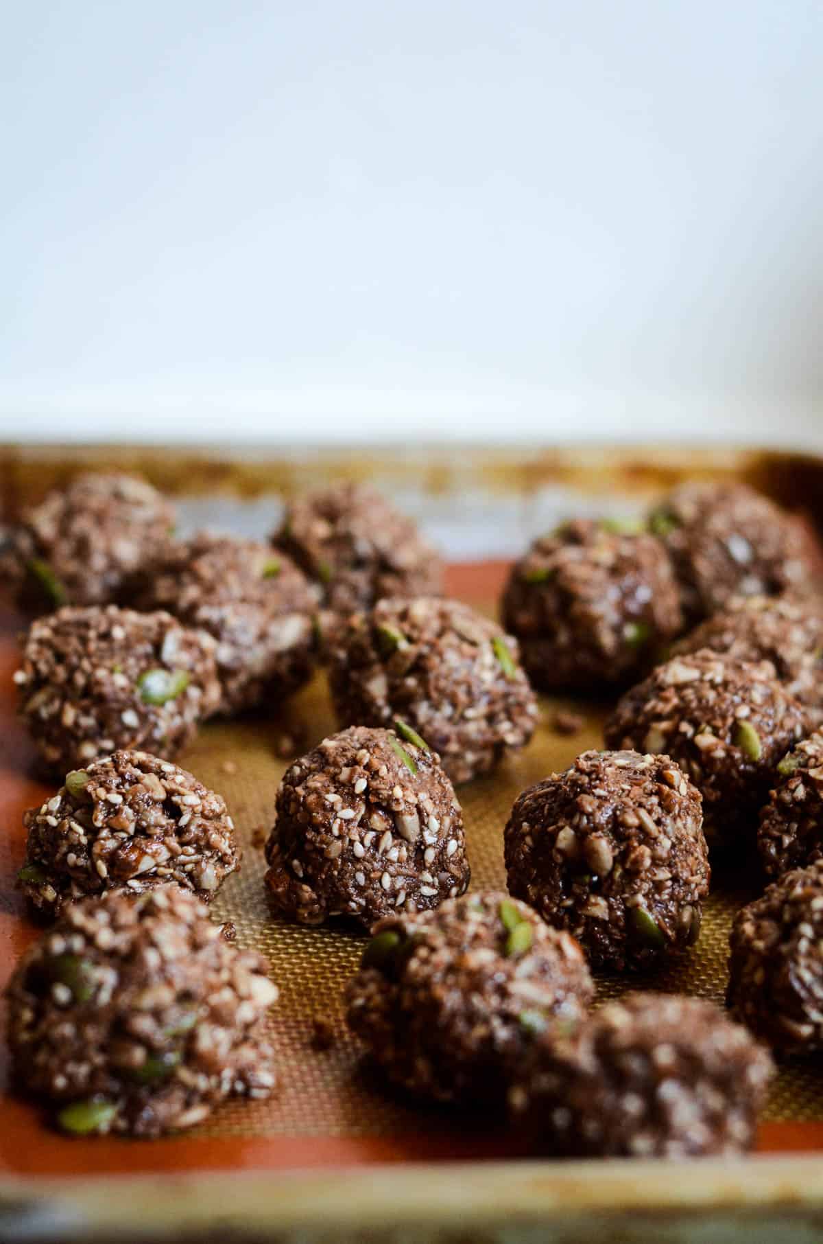 Raw energy balls on a pan ready to go in the fridge.