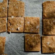 Crackers similar to wheat thins on a baking pan with sea salt.