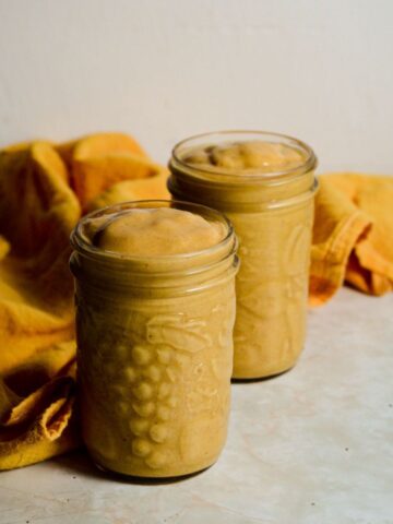 Two pineapple quinoa smoothies in jars.