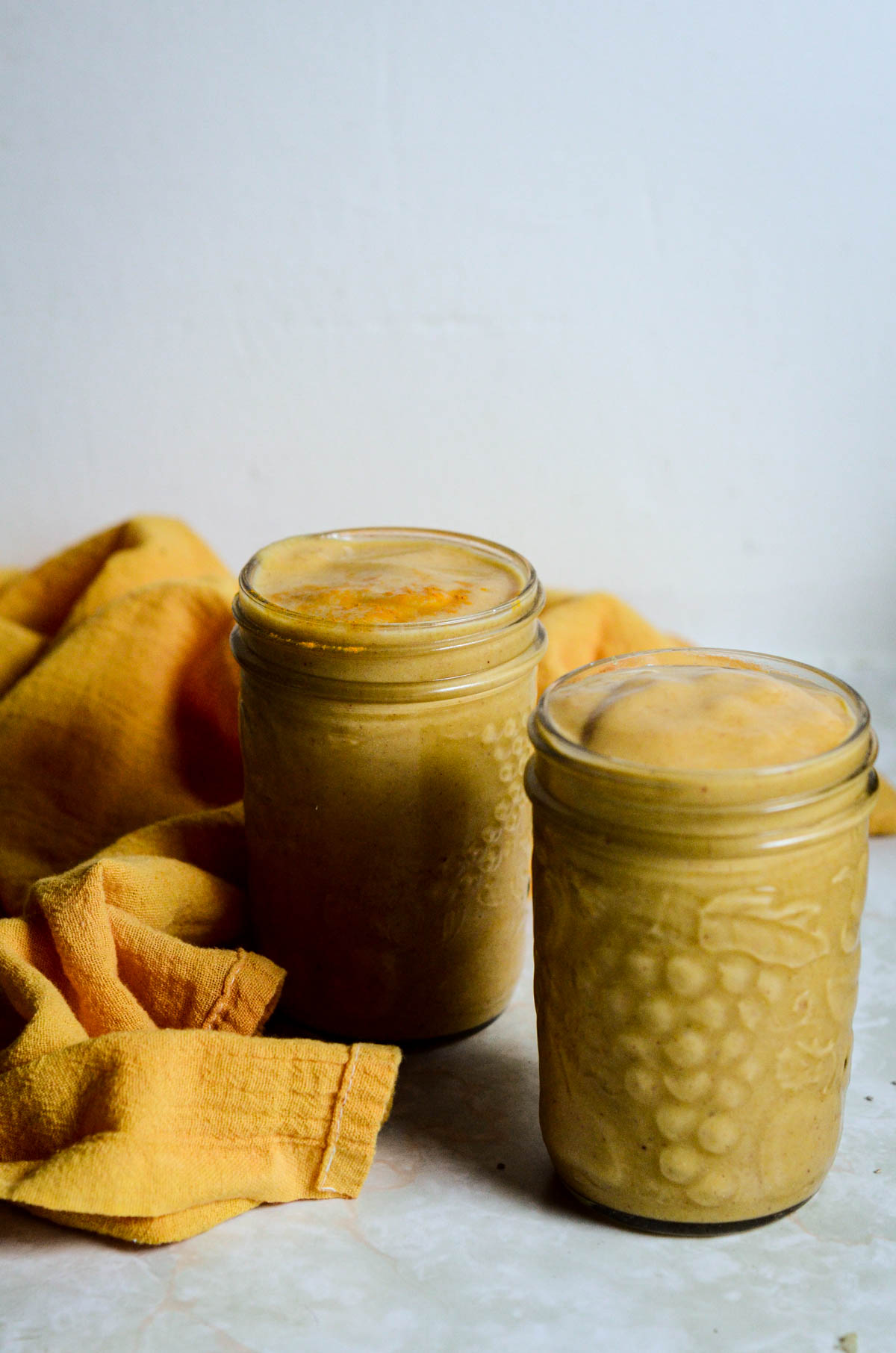 Yellow pineapple smoothies in jars.