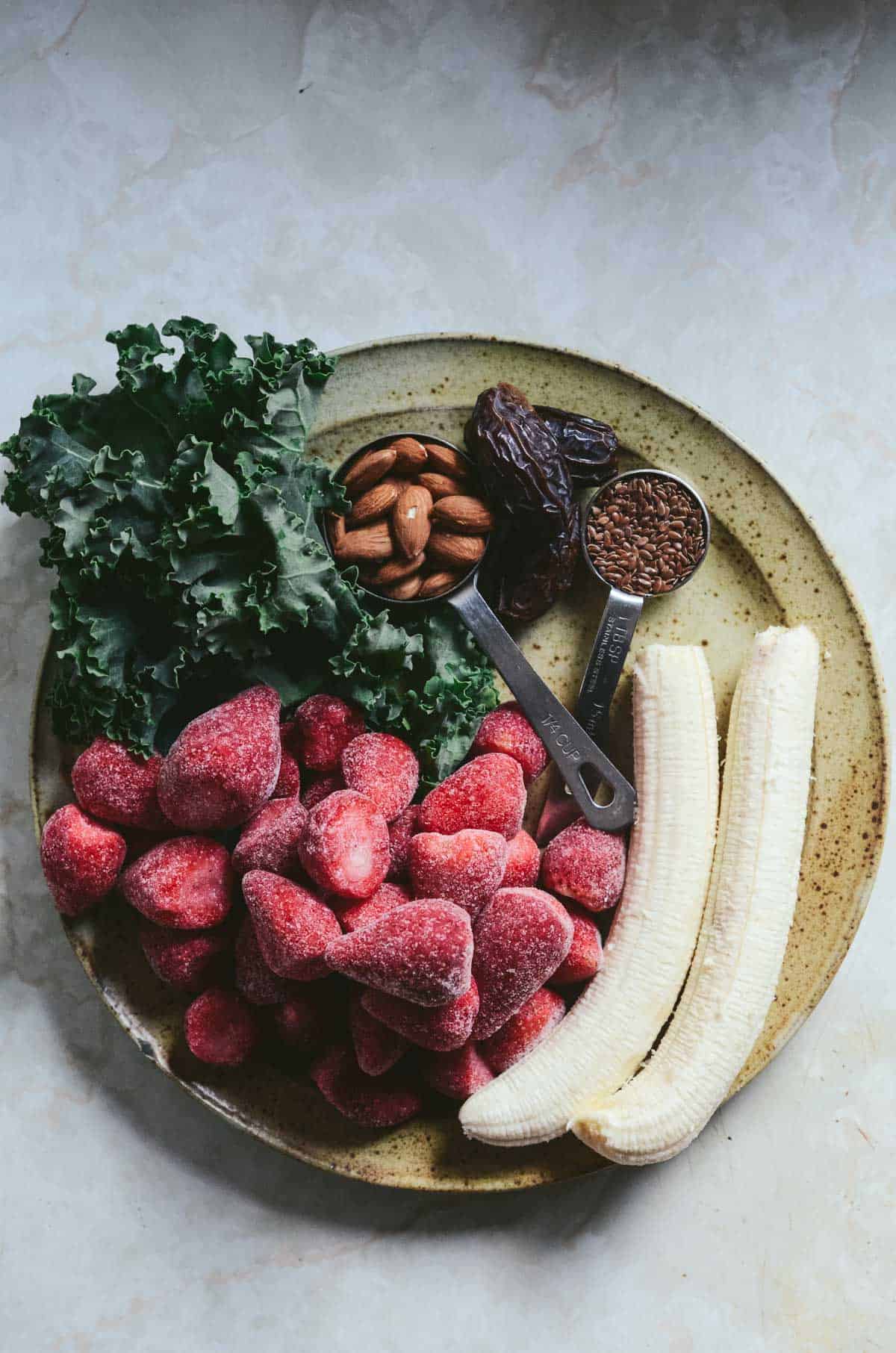 Ingredients for strawberry smoothie on plate.