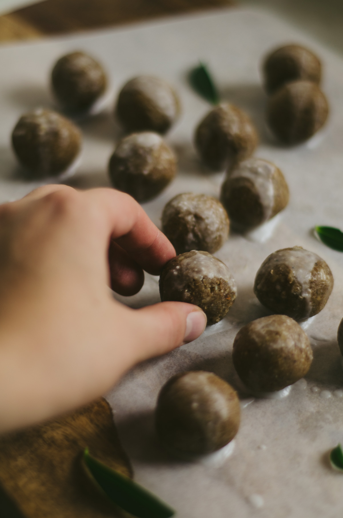 Hand grabbing for a fresh ginger protein ball.