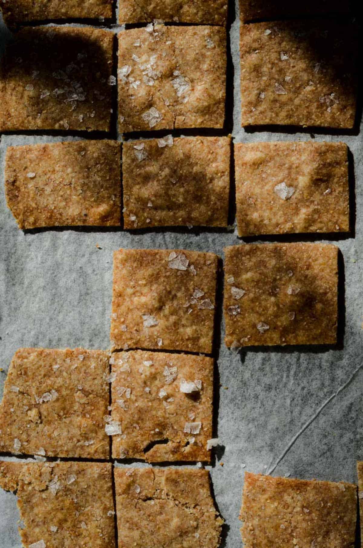 Crackers on baking pan cut into squares with sea salt on top.