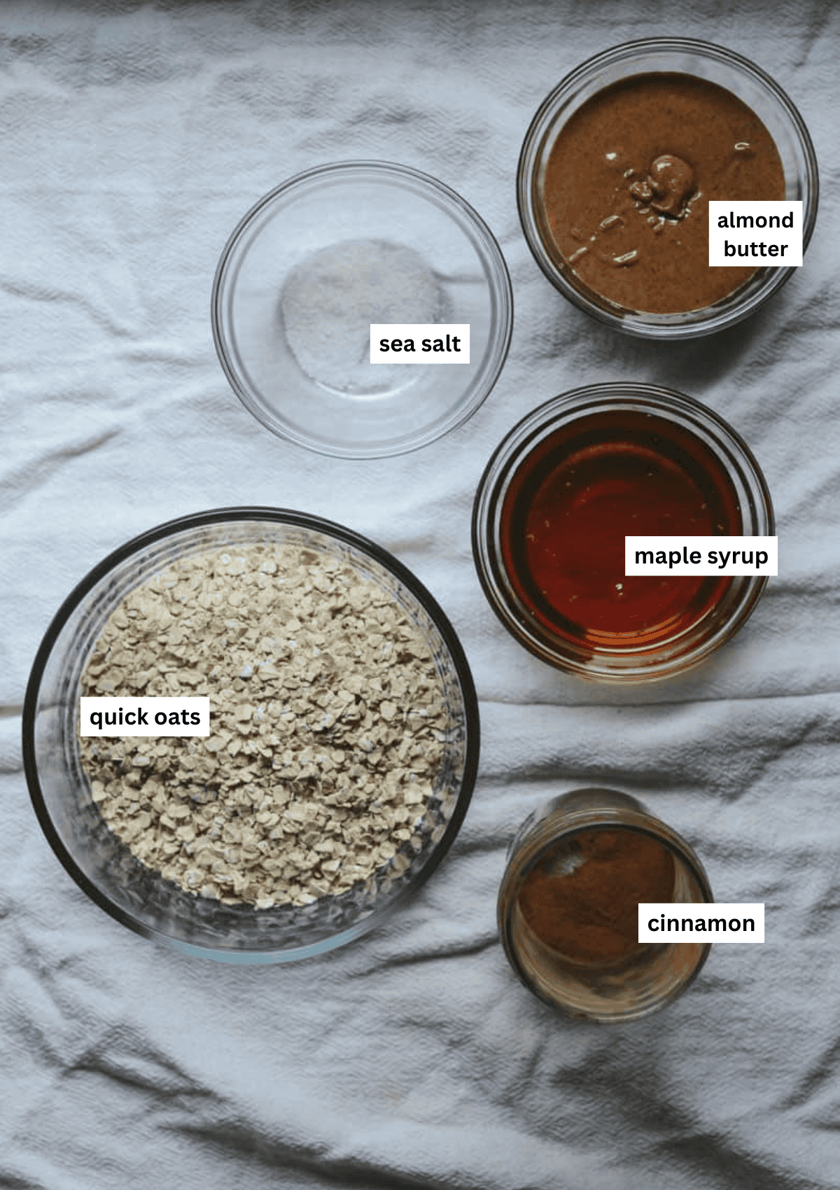 A labelled photo of granola bars ingredients including quick oats, sea salts, almond butter, maple syrup,cinnamon.