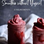 Thick bright pink strawberry smoothie in two jars.