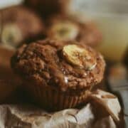 Whole wheat banana muffin with cinnamon and banana slice on top.