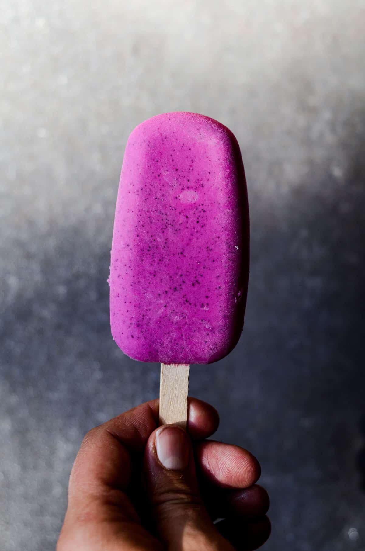 Homemade bright purple pitaya popsicle.