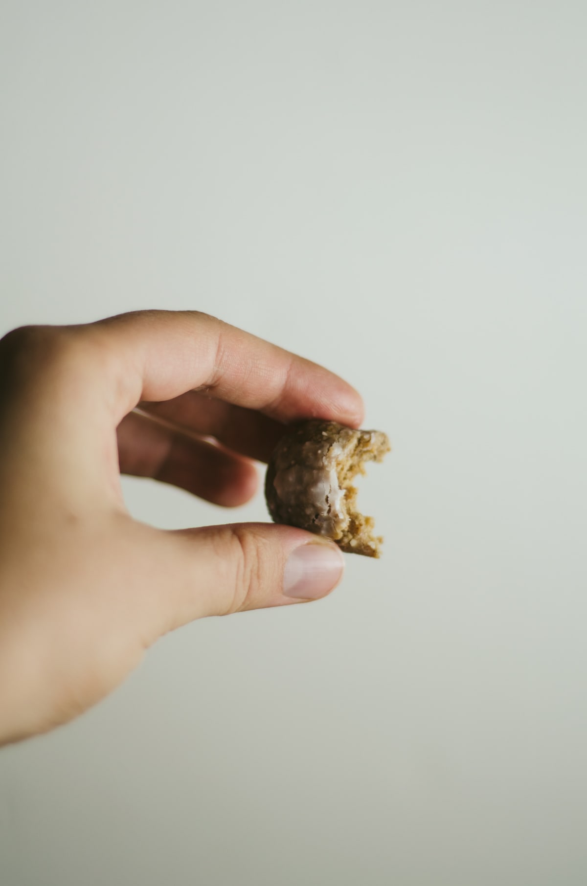 a hand holding a gingersnap raw ball.