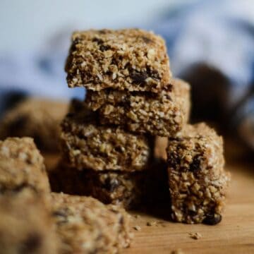 Stacked oat and chocolate heavenly chunks on a wood cutting board.