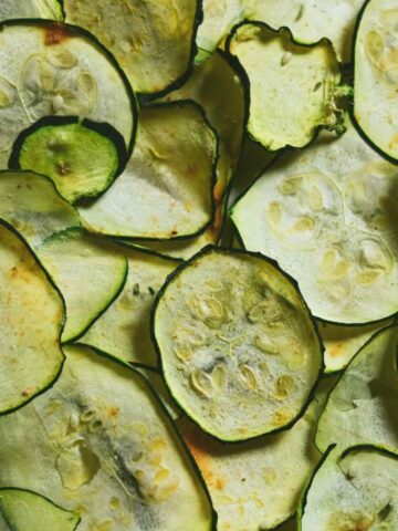 Dehydrated zucchini chips laying flat over lapping each other.