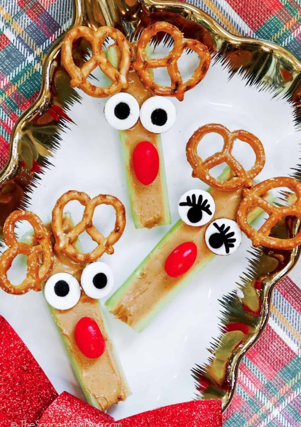 Celery sticks with peanut butter insides reindeer faces from pretzels.
