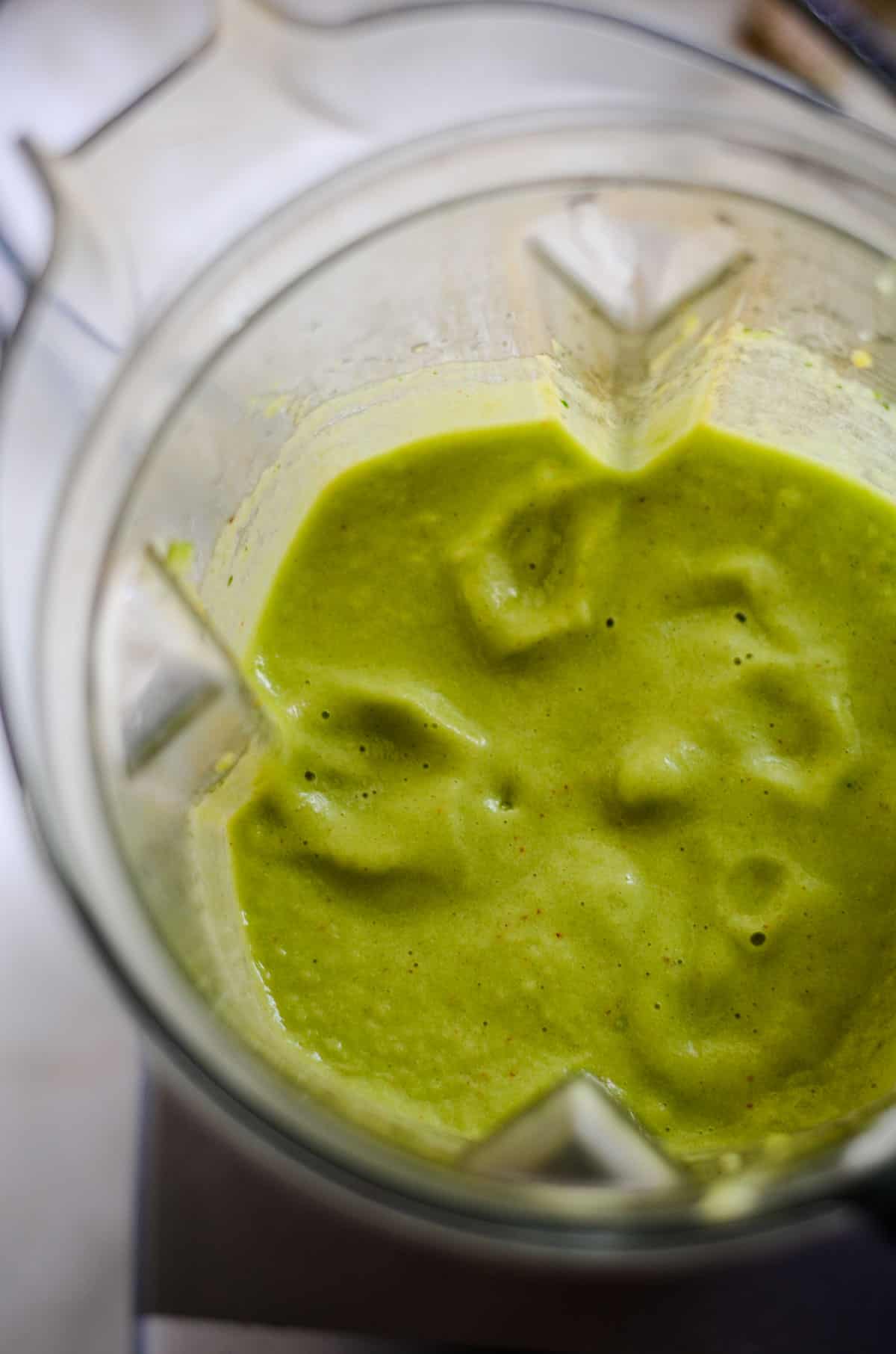 Blended light green smoothie in blender container. 