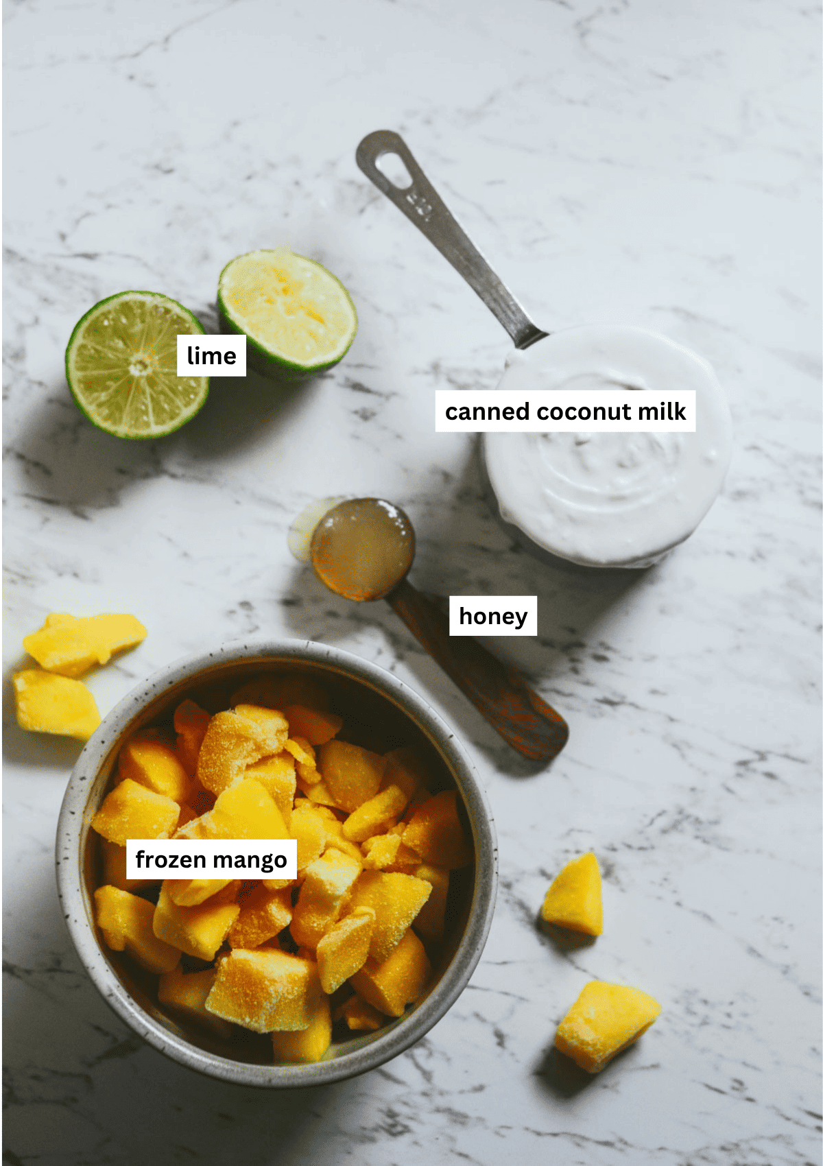 Mango, limes, honey, and coconut milk on the counter.