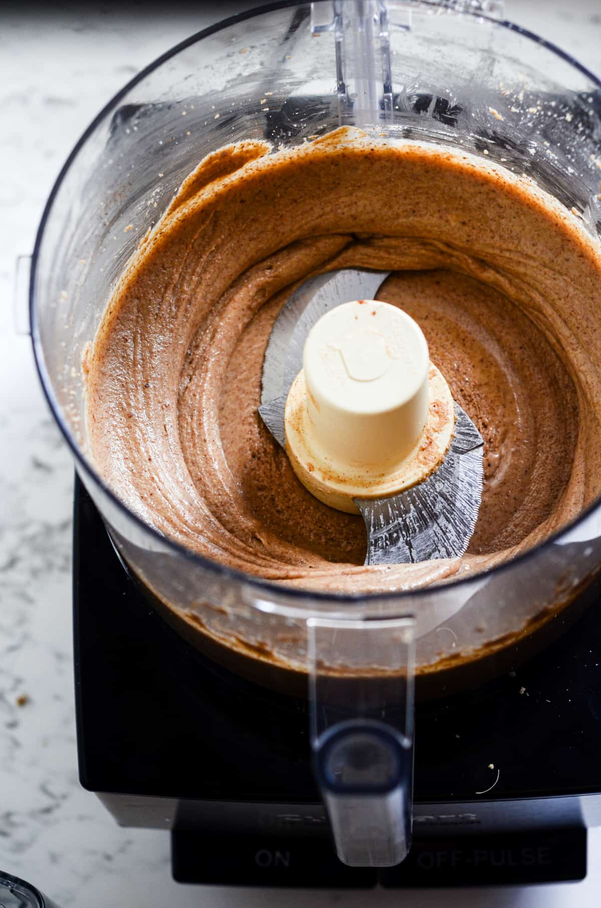Thin brown almond butter in food processor.