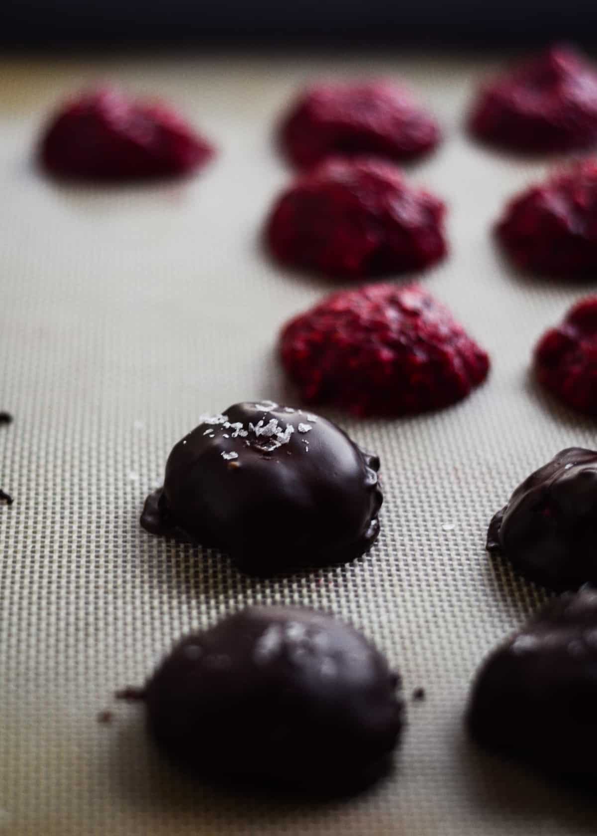 Raspberry chia jam mounds covered in dark chocolate with sea salt.