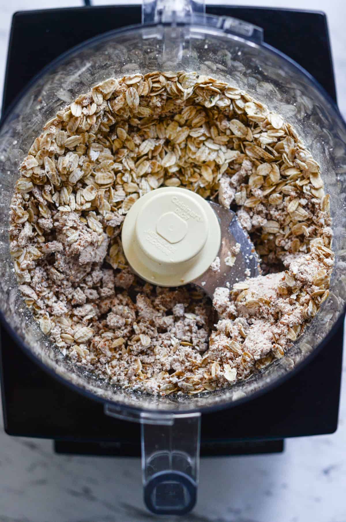 Rolled oats and almond pulp being mixed together.