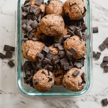Brown energy balls with chocolate chunks in it.