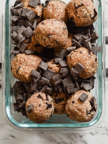 Brown energy balls with chocolate chunks in it.