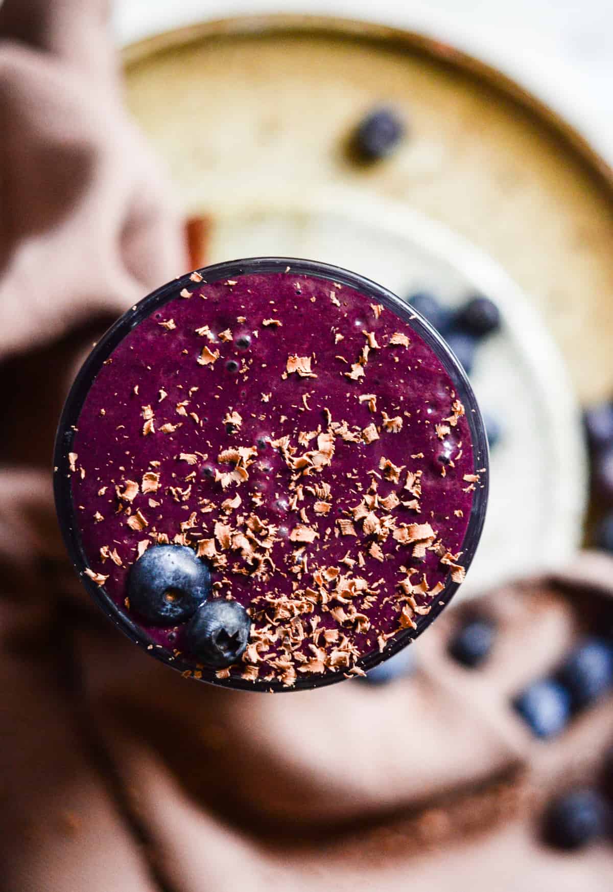 Flat lay of a purple smoothie with chocolate shavings on top.