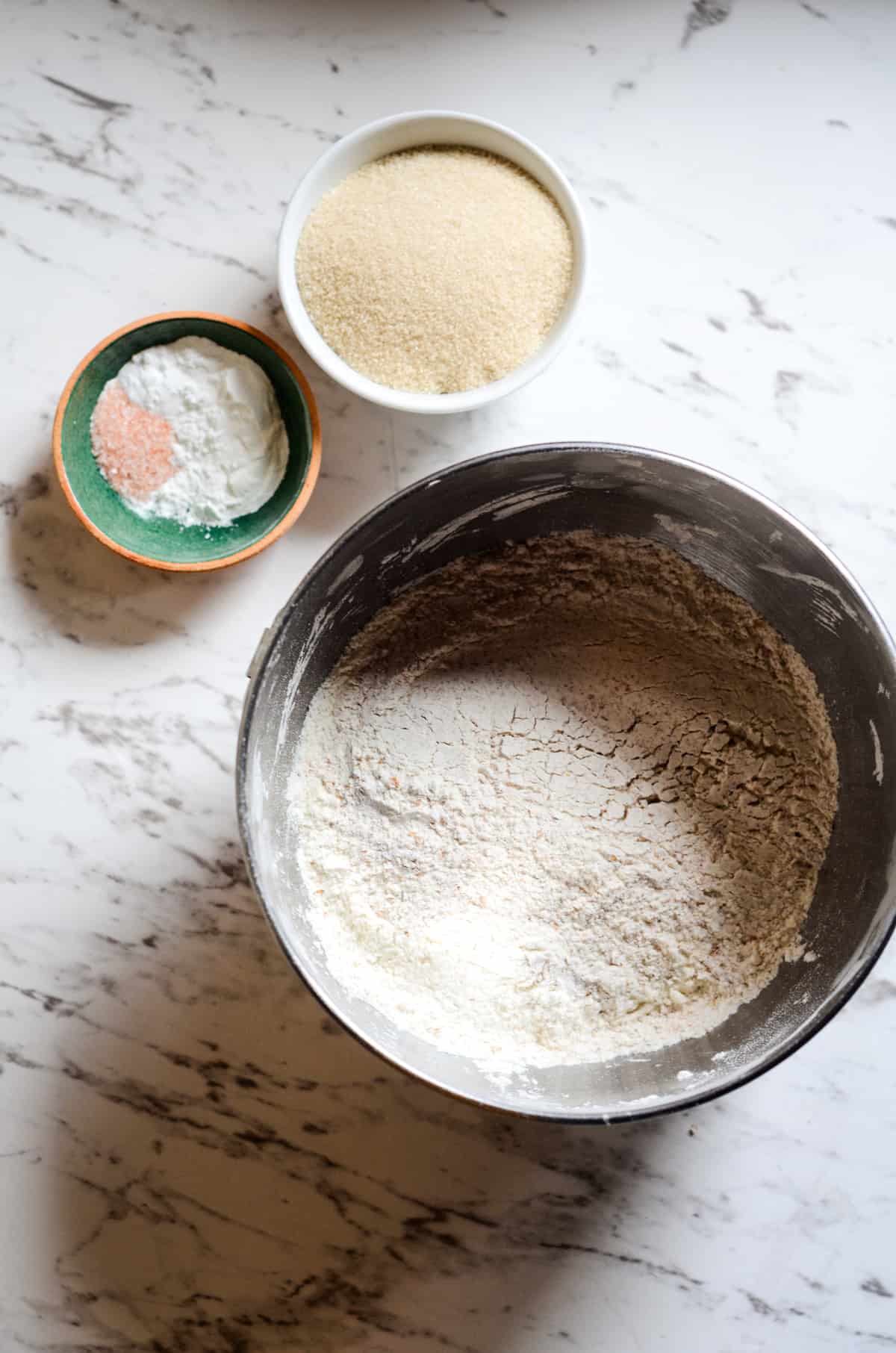 Flour in a medium bowl, sea salt and baking soda, baking powder and cane sugar in bowls. 