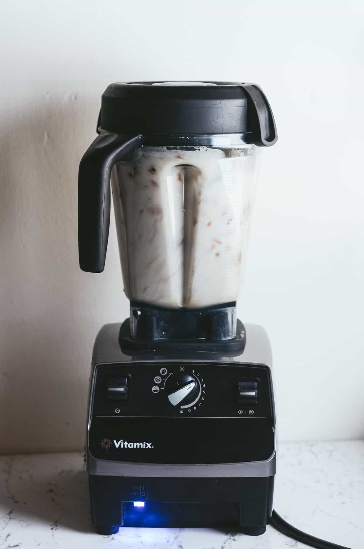 Almonds being blended with water in a vitamix.