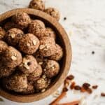 Brown energy balls with rolled oats and chocolate chips sprinkled on top.