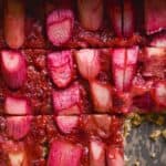 Bright pink squares of oat bars with rhubarb slices on top.