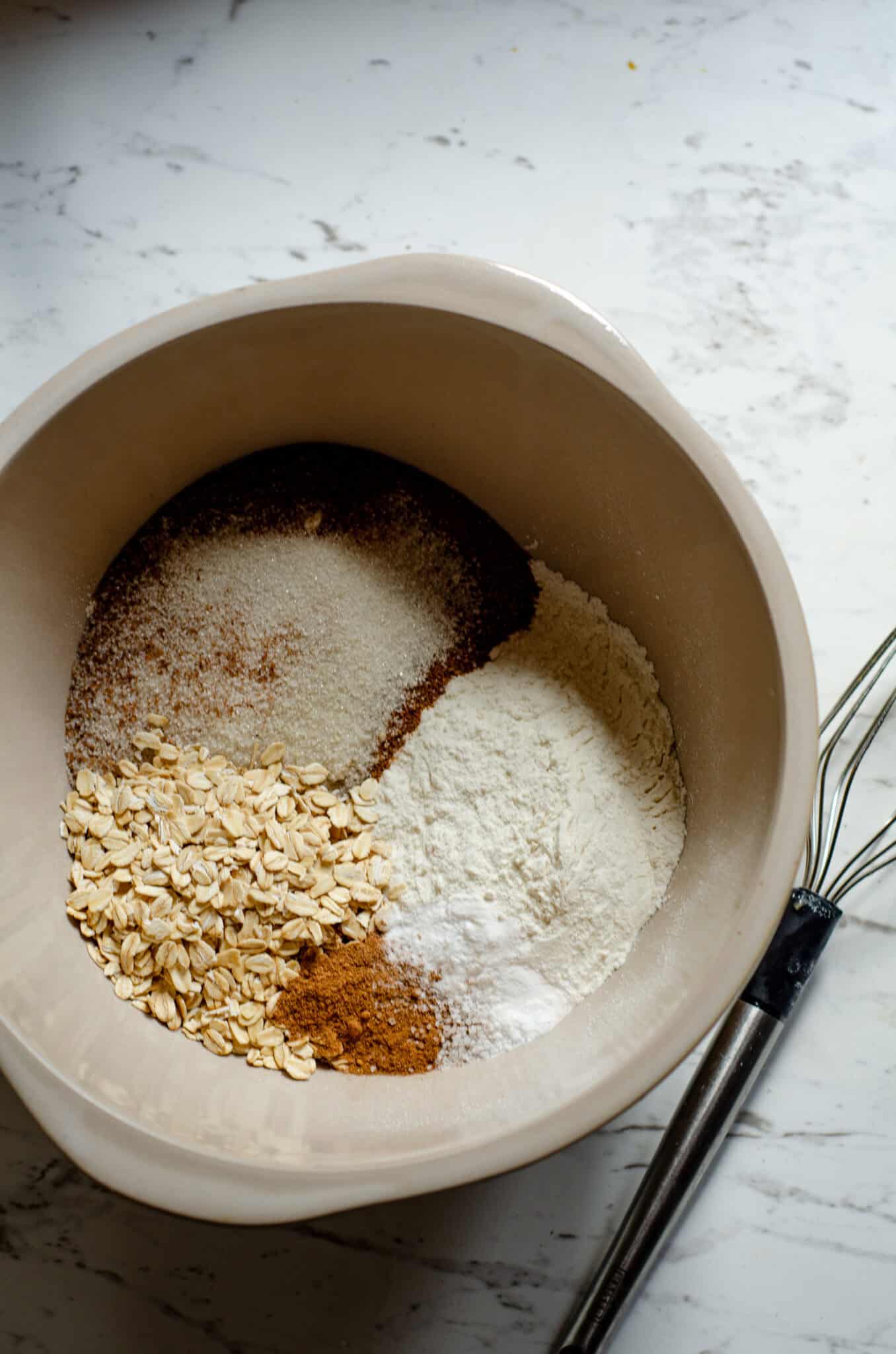 Flour, cinnamon, baking soda, oats, white sugar, brown sugar in a bowl.