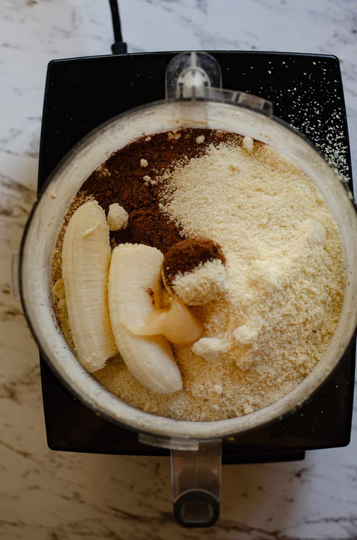 A banana, honey, cocoa powder, almond flour, in a food processor with ground oats.