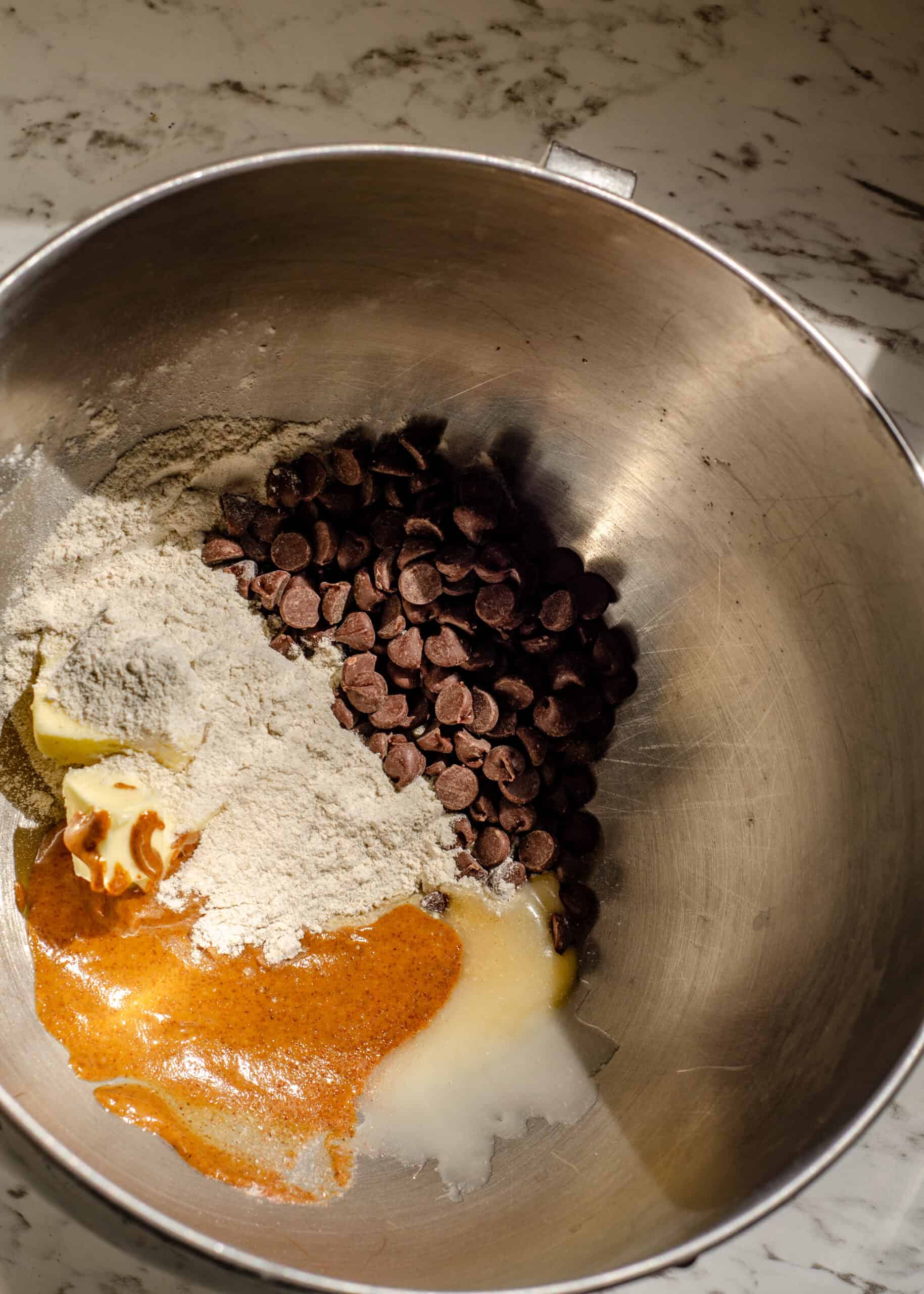 Butter, chocolate chips, buckwheat flour, nut butter, honey, sea salt, and vanilla in a mixing bowl.