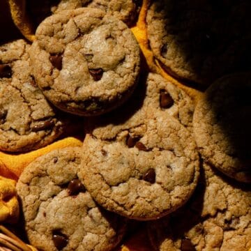 Fresh baked homemade whole wheat cookies with still melted chocolate chips in harsh lighting.