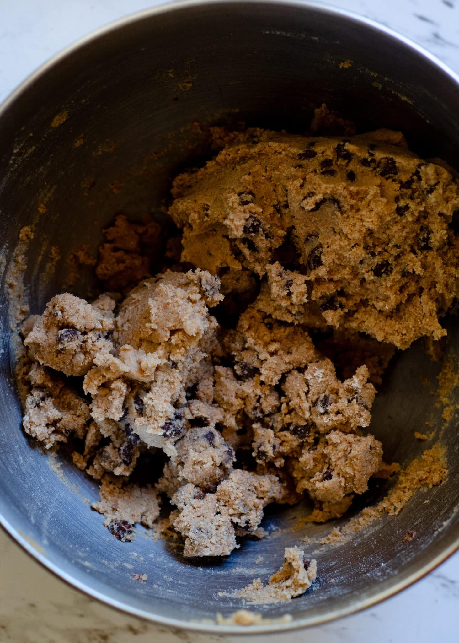 The perfect texture of chocolate chip cookie dough in the kitchen aid metal bowl.
