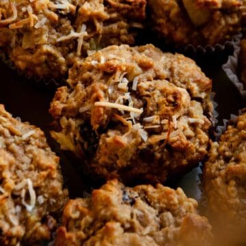A close up of a morning glory muffin with toasted coconut on top.