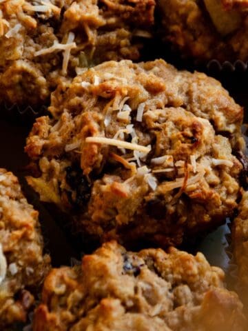 A close up of a morning glory muffin with toasted coconut on top.