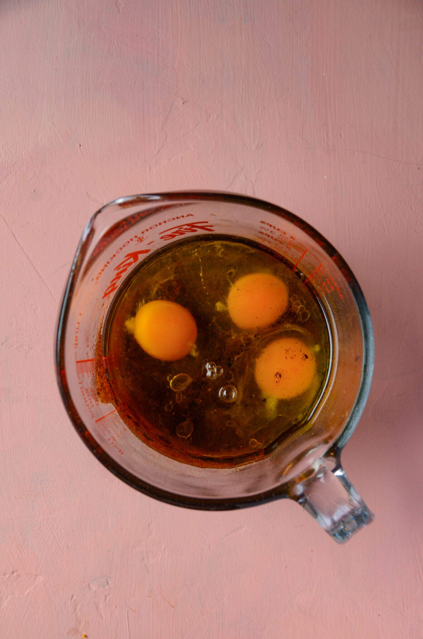 Eggs, coconut sugar, eggs, water, vanilla in a large glass measuring cup.