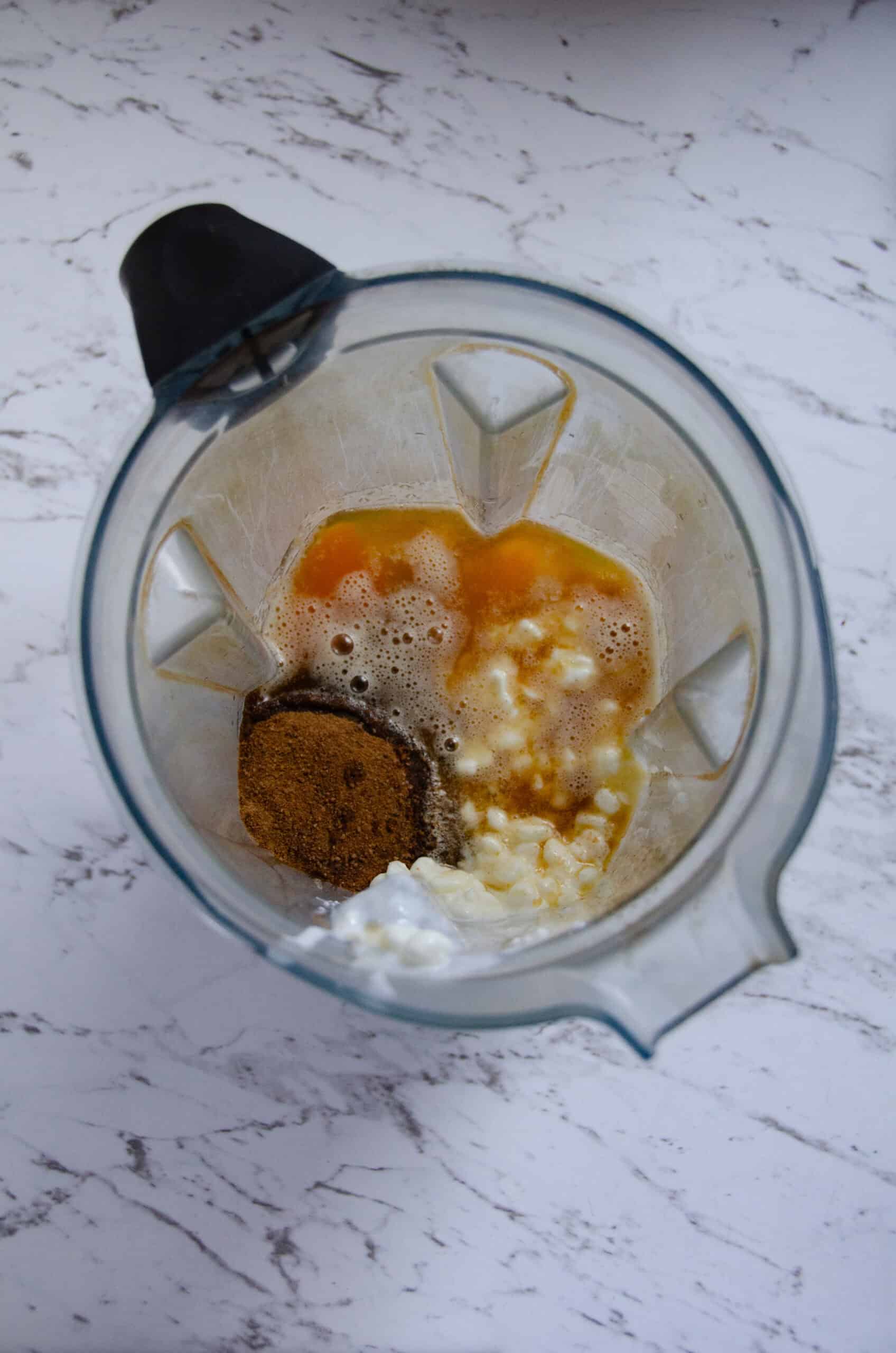 A vitamix with ingredients for protein muffins.