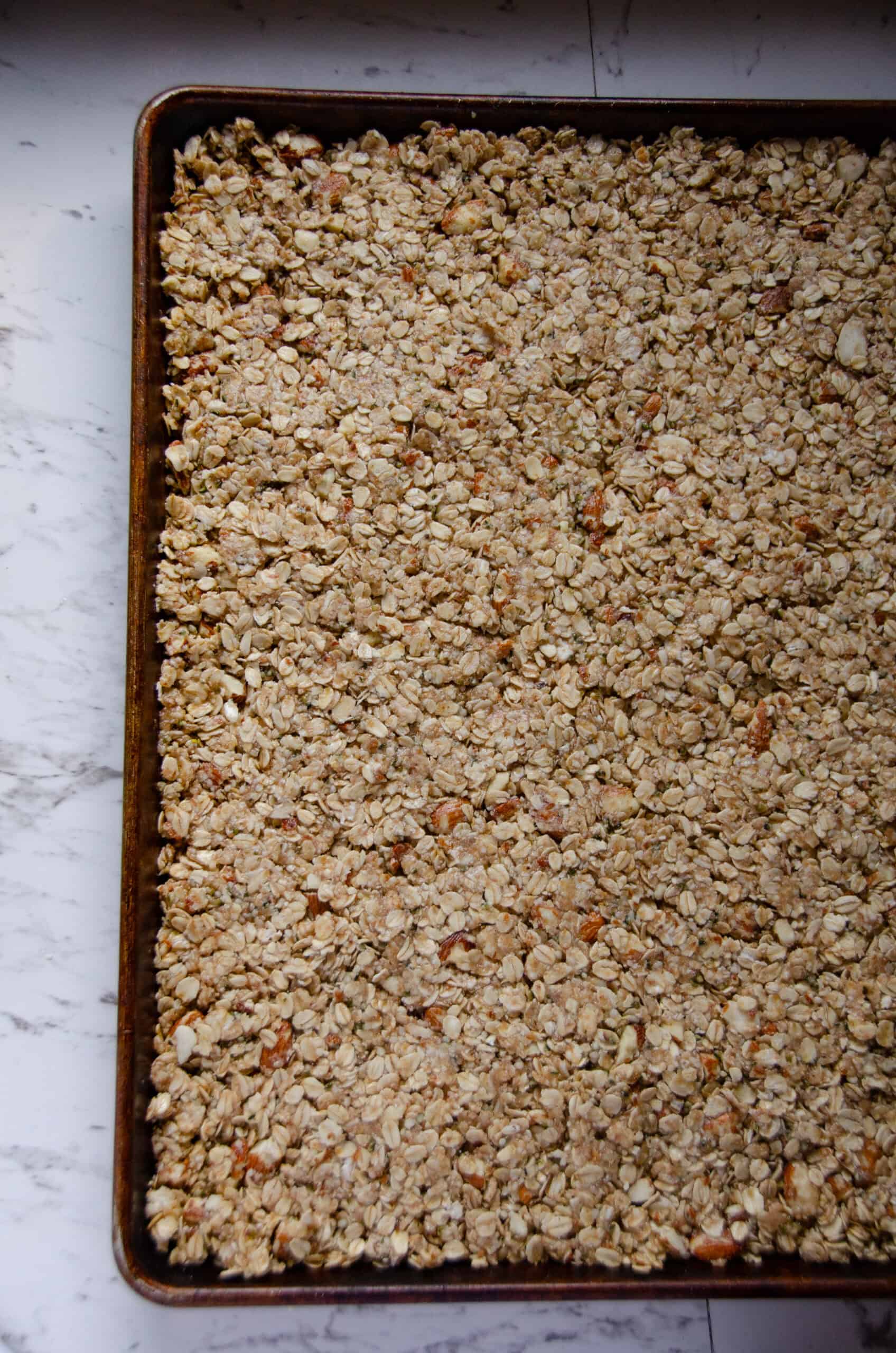 A sheet pan of granola pressed down.