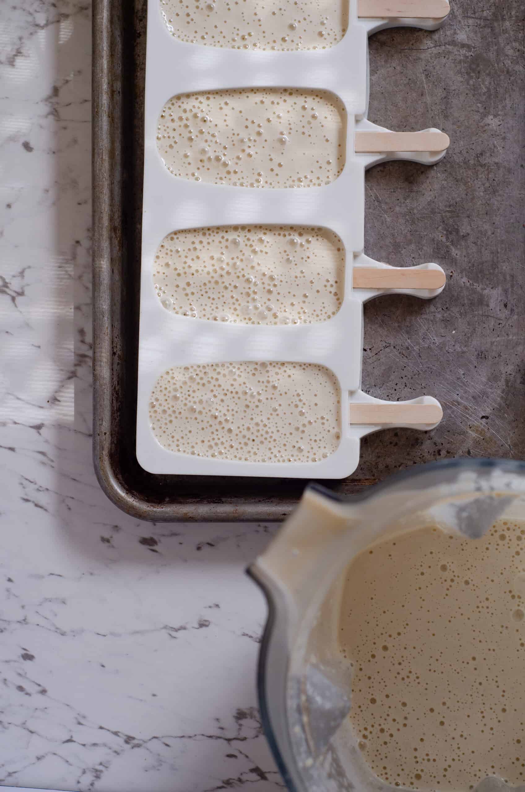 Filling the silicone popsicle mold with cashew ice cream.