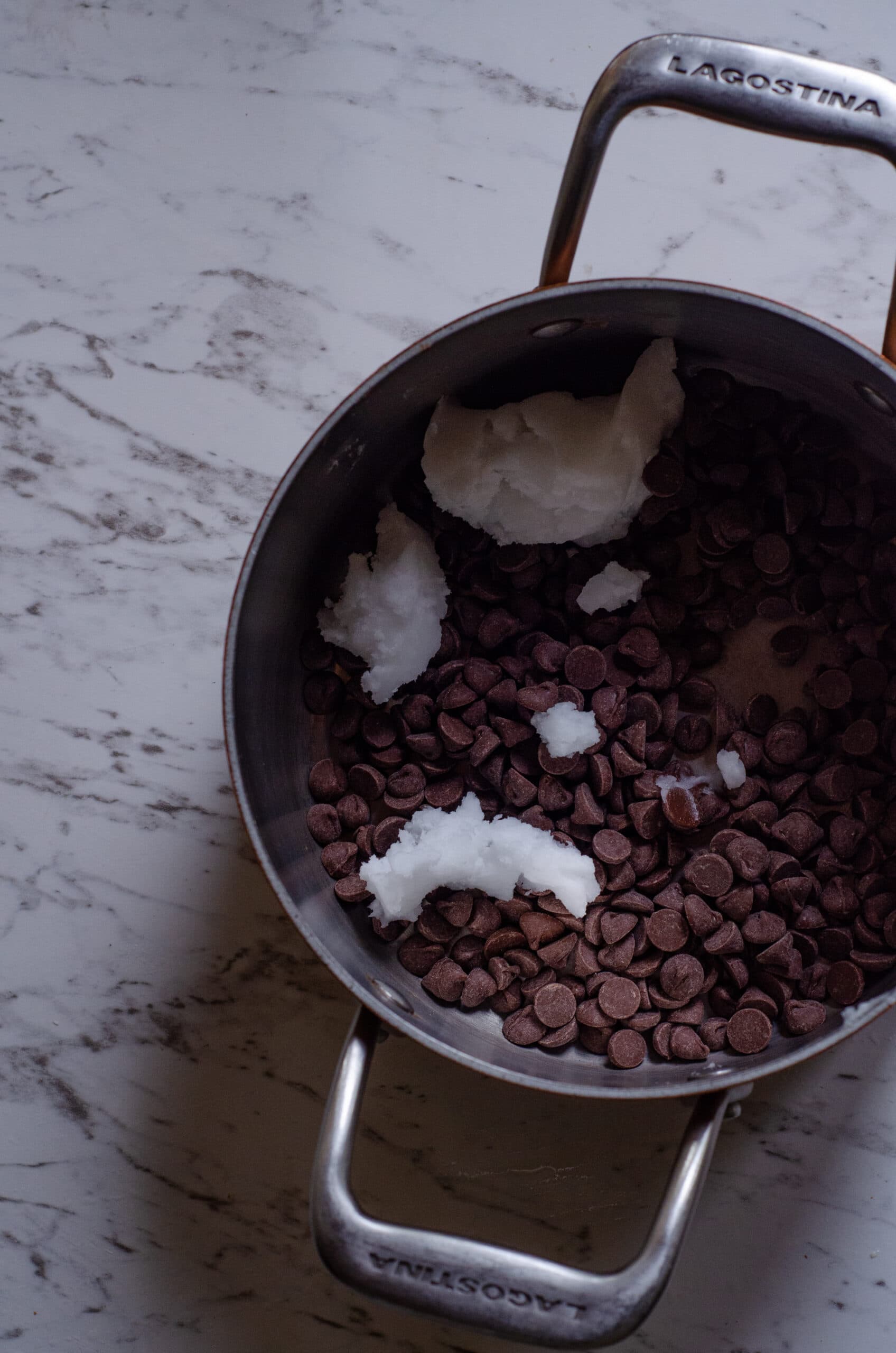 Chocolate chips and coconut oil in pot to be melted.