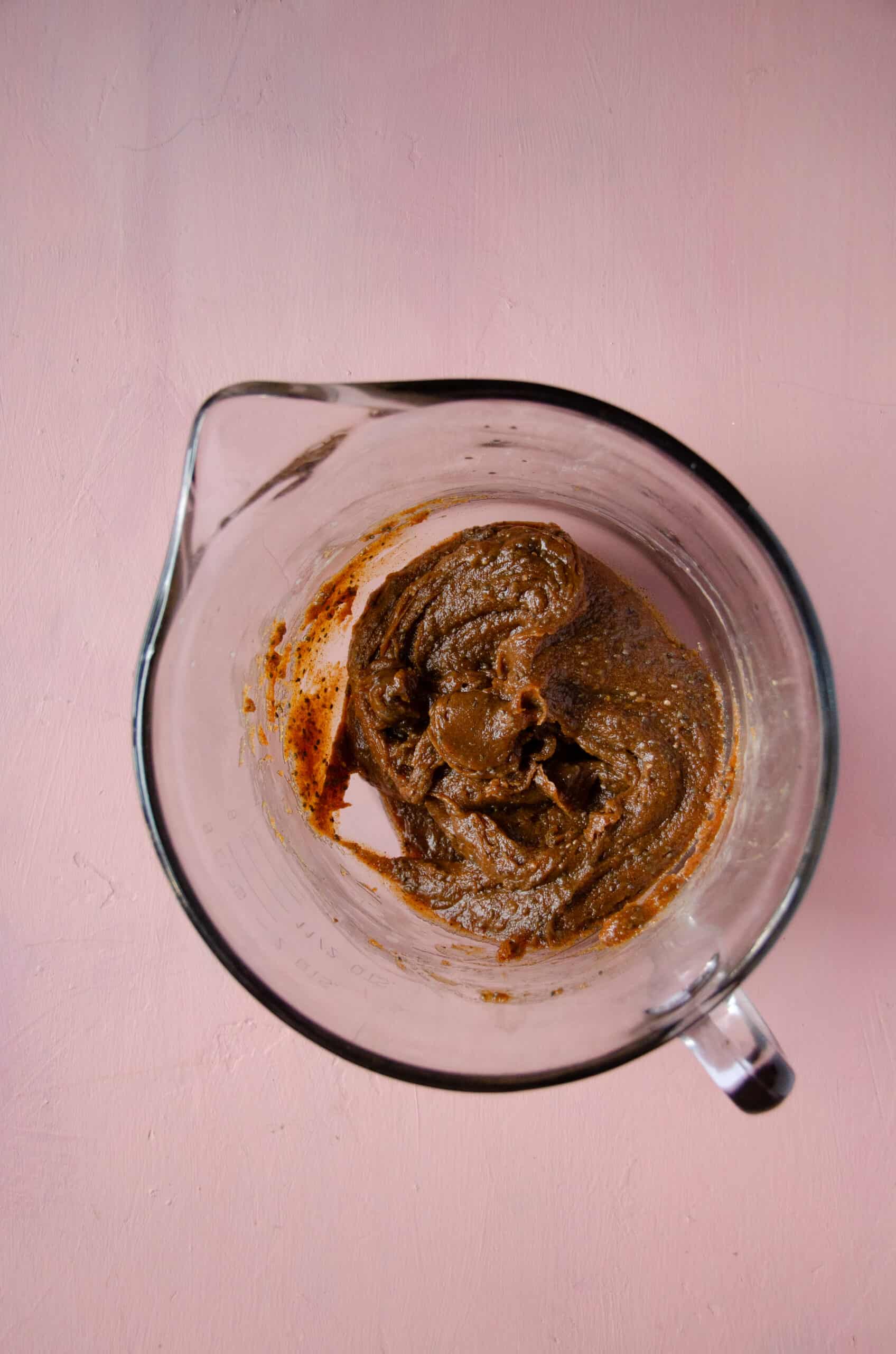 A glass mixing bowl with ingredients for energy balls with hemp.