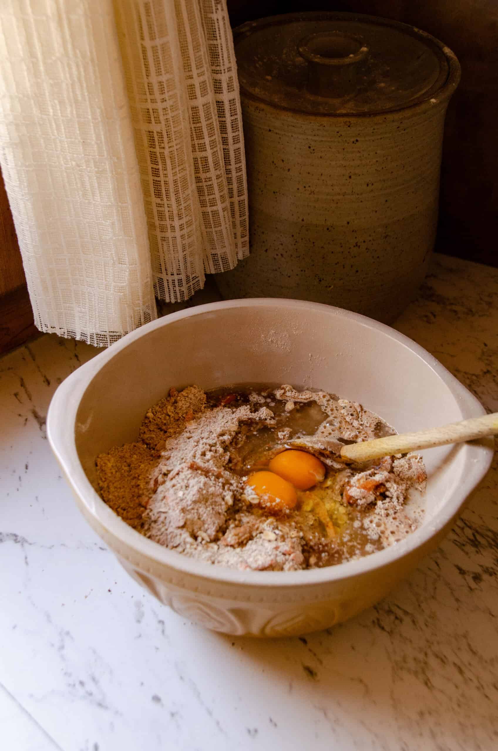 Eggs, oil, and water, being added to a mixing bowl.