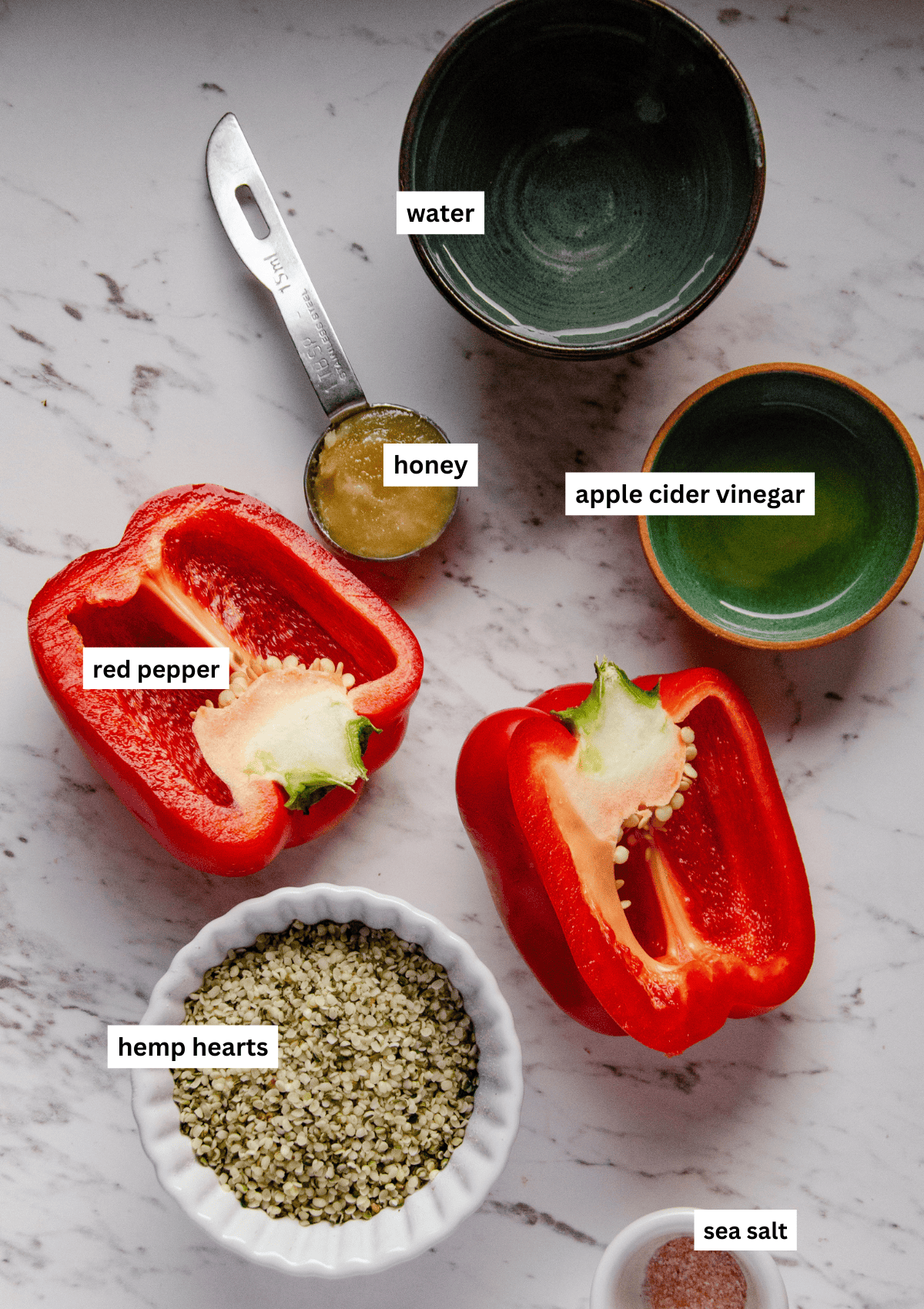 Labelled ingredient photo of a red pepper, hemp hearts, honey, water, and apple cider vinegar, and sea salt.