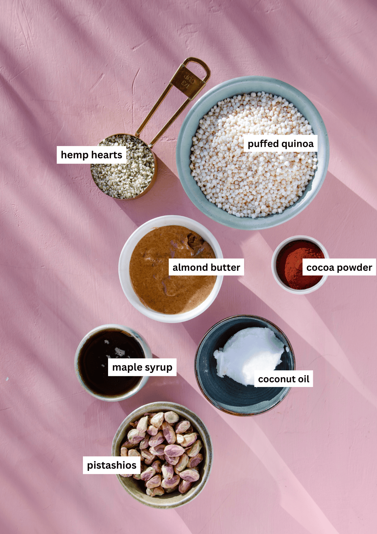 Labelled ingredients coconut oil, puffed quinoa, cocoa powder, pistachios, sea salt, hemp hearts.