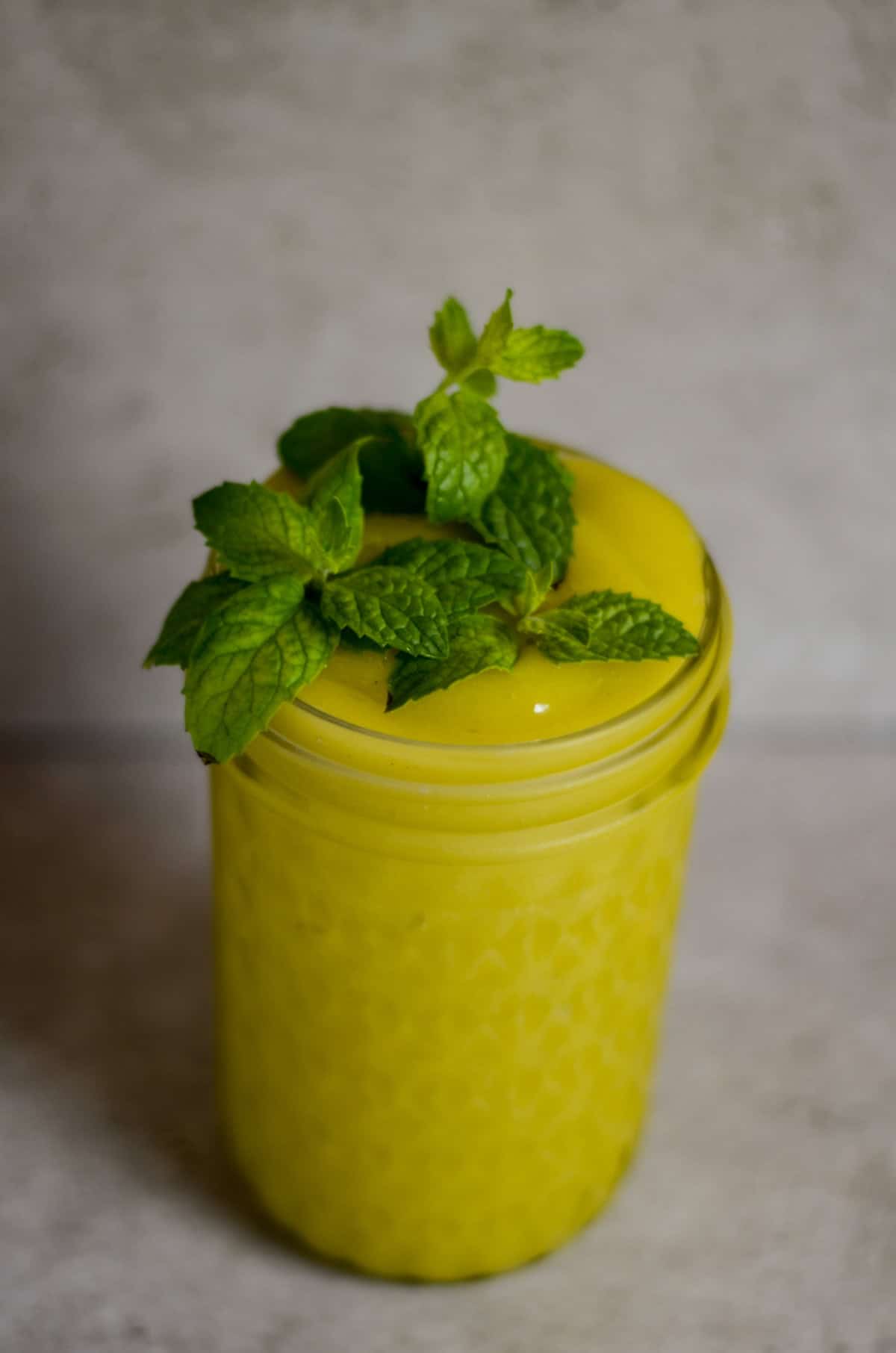 Bright neon yellow slushy with fresh mint on top. 